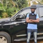 Bobi Wine next to his bulletproof car